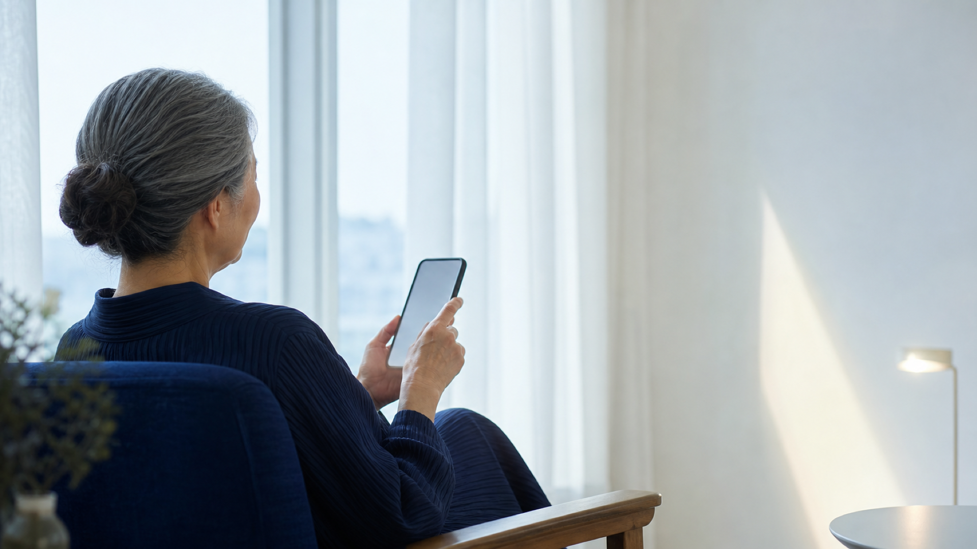 朝の光の中でスマートフォンを手にする女性